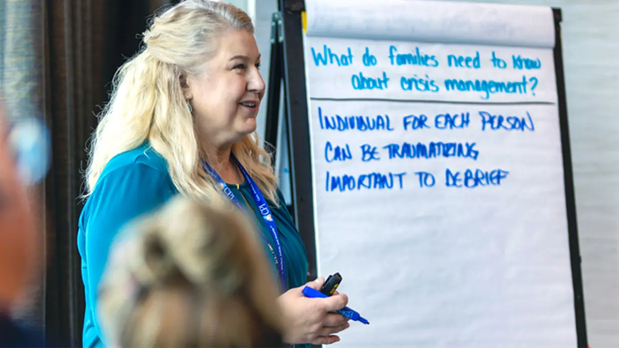A CPI training speaking in front of a flip chart.